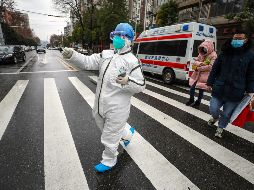 Un trabajador en atuendo protector especial dirige hoy a pacientes a un hospital en Wuhan. AP/Chinatopix