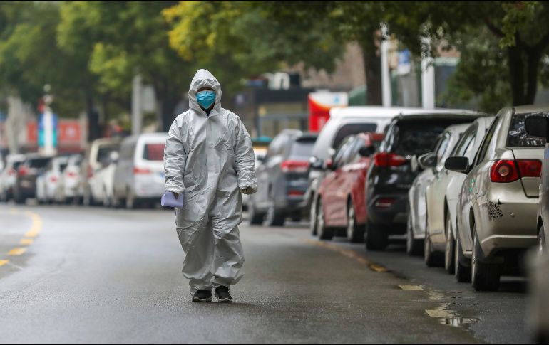 Un trabajador del sector salud camina hoy por una calle de Wuhan. La ciudad está en cuarentena, por lo que no hay transportes para salir ni llegar a ella. AP/Chinatopix