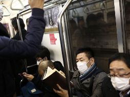 Usuarios del metro en Tokio, Japón, usan cubrebocas para protegerse de virus. AFP/B. Mehri