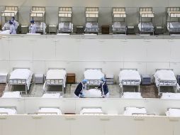 Personal médico prepara camas en un hospital improvisado en un centro de exposiciones para atender a enfermos de coronavirus. AP/Chinatopix