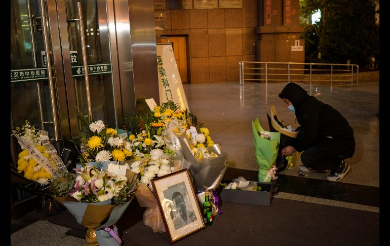 Un hombre deja hoy flores en memoria del médico Li Wenliang, afuera del hospital en Wuhan. EFE/Shi Zhi