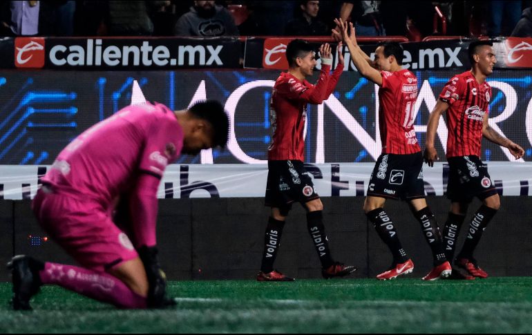 Alexis Castro celebra con Erick Torres, que le puso el pase para el primer gol del partido. AFP/G. Arias