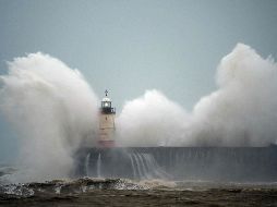 Olas se estrellan junto al faro Newhaven, en Inglaterra. AFP/G. Kirk