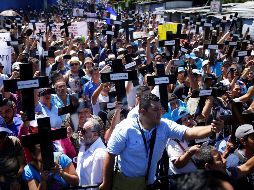 Los asistentes portaban pancartas con mensajes de respaldo a Bukele y unas cruces negras que colocaron frente a la entrada principal del recinto legislativo. EFE