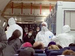 Ciudadanos estadounidenses evacuados del crucero se ven en avión que los trasladó de Tokio a EU. AP/C. y P. Molesky