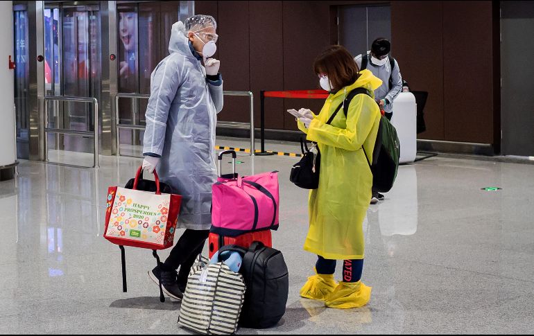 Pasajeros en el aeropuerto Daxing en Pekín usan protectores para evitar el contagio del nuevo coronavirus. AFP/N. Asfouri