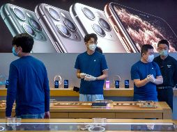 Empleados con mascarillas en la reapertura de una tienda Apple en la capital china. AP/M. Schiefelbein