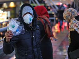 Un vendedor callejero ofrece máscaras protectoras en un mercado de Teherán, en Irán, ante la amenaza del coronavirus en el país. AFP/A. Kenare