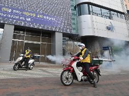 Personal de salud rocía desinfectante frente al templo Shincheonji en Daegu, Corea del Sur. AFP/Jung Yeon-je