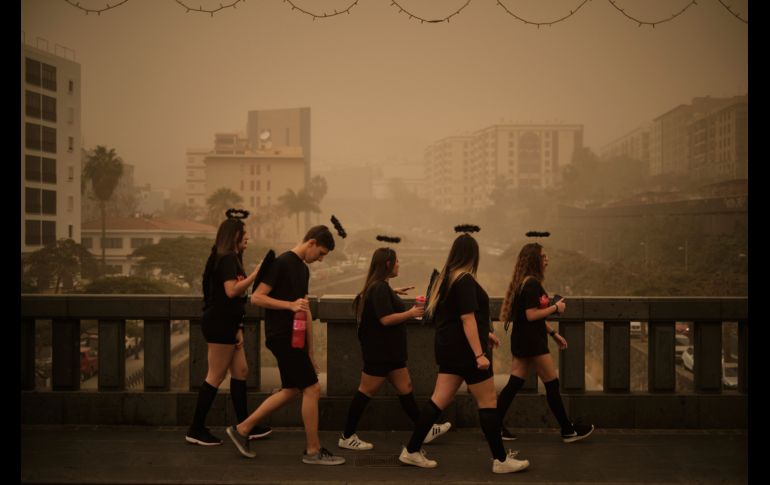 Personas en atuendos de carnaval caminan por un puente  Santa Cruz de Tenerife. AP/A. Gutierrez