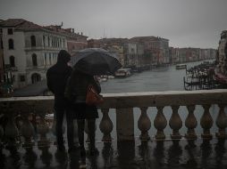 Una pareja se ve hoy en el puente Rialto en Venecia. El coronavirus está impactando en el turismo. AP/F. Seco