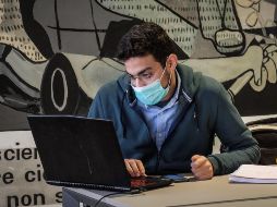 Un estudiante del Politécnico de Milán usa hoy una mascarilla dentro de la biblioteca de la universidad. El cierre comienza mañana. EFE/EPA/M. Corner