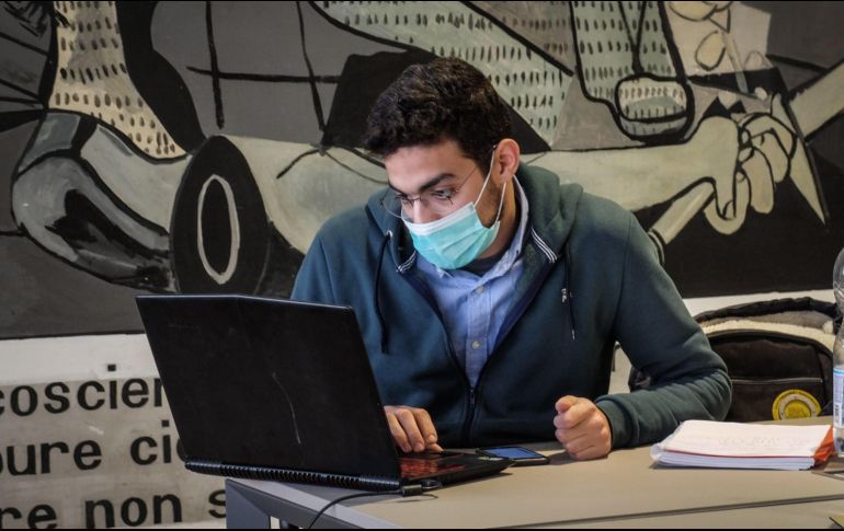 Un estudiante del Politécnico de Milán usa hoy una mascarilla dentro de la biblioteca de la universidad. El cierre comienza mañana. EFE/EPA/M. Corner