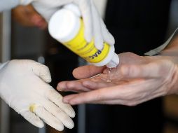 Una funcionaria de sanidad reparte gel antibacterial a los viajeros que llegan este jueves al aeropuerto internacional El Dorado, en Bogotá, Colombia. EFE/C. Ortega