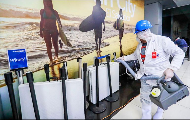 Miembros del Ministerio de Salud de El Salvador rocían desinfectante AM500 en el Aeropuerto Internacional San Oscar Arnulfo Romero, en la ciudad de San Salvador. AFP/PRESIDENCIA DE EL SALVADOR
