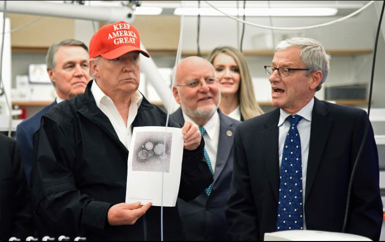Donald Trump con una foto del coronavirus en los Centros para el Control y la Prevención de Enfermedades. AP/H. Shin