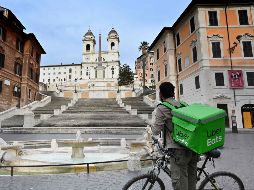 Un repartidor de comida se ve una vacía Plaza España en Roma. Todos los comercios permanecen cerrados en el país, salvo aquellos de alimentos y farmacias. AFP/A. Pizzoli