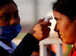 Una enfermera toma la temperatura como medida preventiva contra el Covid-19. AFP / U. Ruiz