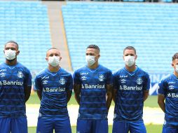 Jugadores y cuerpo técnico del Gremio de Porto Alegre, antes del juego contra el Esporte Clube Sao Luiz, salió a la cancha con cubre bocas en modo de protesta hacia las autoridades que no paran la liga. EFE