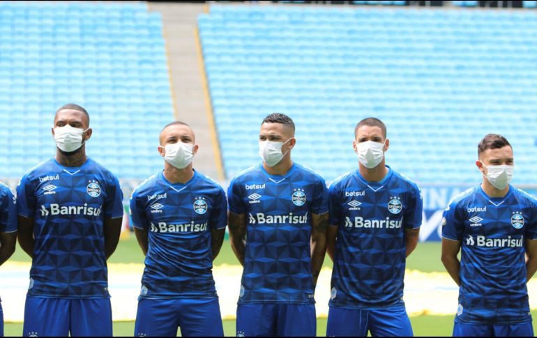 Jugadores y cuerpo técnico del Gremio de Porto Alegre, antes del juego contra el Esporte Clube Sao Luiz, salió a la cancha con cubre bocas en modo de protesta hacia las autoridades que no paran la liga. EFE