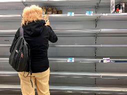 Una mujer junto a  anaqueles vacíos hoy en un supermercado en Buenos Aires. Habitantes realizan compras de pánico antre las medidas para contener el coronavirus. AFP/R. Schemidt