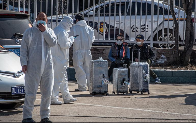 Pasajeros aguardan en Pekín junto al Nuevo Centro Internacional de Exposiciones de China, habilitado en un centro de tránsito para los viajeros entrantes internacionales. EFE/R. Pilipey