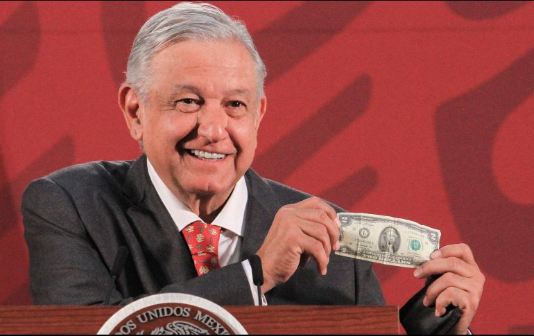 El Mandatario muestra un billete de dos dólares que le regaló un migrante. NTX / J. Lira