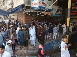 Decenas de personas posan afuera de sus tiendas, cerradas como medida de prevención ante el avance del COVID-19, en la provincia de Karachi. AP/F. Khan