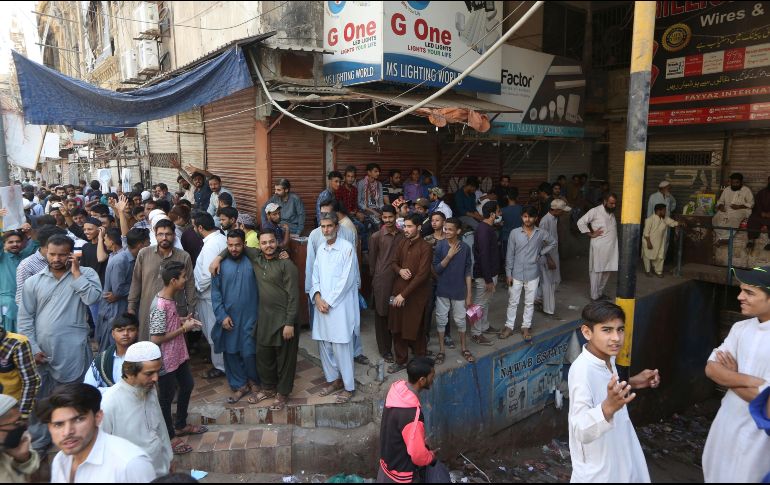 Decenas de personas posan afuera de sus tiendas, cerradas como medida de prevención ante el avance del COVID-19, en la provincia de Karachi. AP/F. Khan