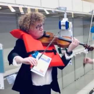 Violinistas tocan melodía de "Titanic" frente a estantes vacíos de papel higiénico