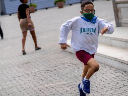 Un niño protegido con un cubrebocas corre por calles de La Habana este viernes. AP/R. Espinosa