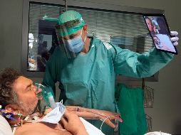 El doctor Matteo Flippini sostiene una tableta para que uno de sus pacientes pueda sostener una videollamada con sus seres queridos. AP/S. Cattaneo