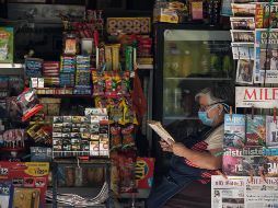 Una mujer porta una mascarilla como medida de protección contra la enfermedad causada por el COVID-19 mientras trabaja en un puesto de revistas, en la Ciudad de México. XINHUA/F. Cañedo