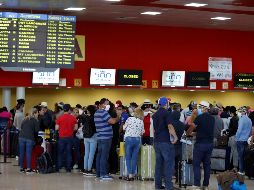 Varias personas esperan la salida de sus vuelos antes del cierre de las fronteras, este lunes, en el aeropuerto de La Habana. EFE/Y. Zamora