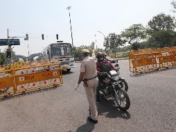 Un policía revisa este martes los permisos de viajeros en Nueva Delhi, que ya está en confinamiento. Al menos 80 distritos donde se detectaron casos ya estaban bajo estrictas cuarentenas. EFE/H. Tyagi
