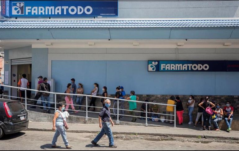 Decenas de personas hacen fila para abastecerse de medicamentos y productos de higiene personal en una farmacia de Caracas. EFE/R. Peña