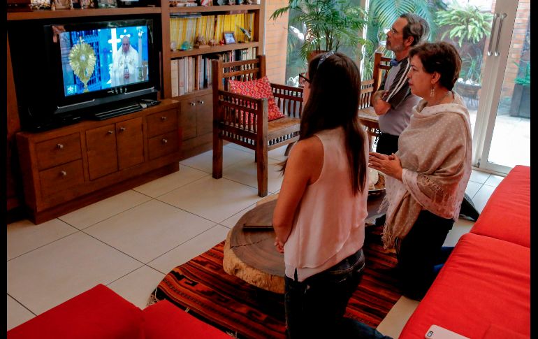 Miles de fieles alrededor del mundo siguieron la transmisión de la bendición papal. En la foto una familia de Guadalajara, Jalisco. AFP / U. Ruiz