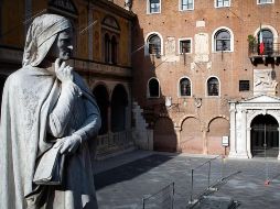 Una estatua del poeta italiano Dante Alighieri (i) se ve en una plaza desierta por el confinamiento en Verona, Italia. EFE/F. Venezia