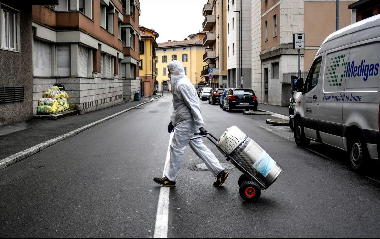 Un trabajador entrega un tanque de oxígeno a enfermos de COVID-19 tratados en casa en Bérgamo. El 59 % de todos los contagiados se están recuperado en aislamiento en sus domicilios. AP/LaPresse/C. Furlan