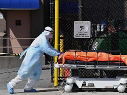 Personal médico traslada un cuerpo de un centro médico a un camión refrigerado en Nueva York. AFP/A.Weiss