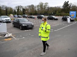 Conductores hacen fila para que les tomen una muestra desde su auto, en un lugar donde se realizan pruebas de coronavirus en Chessington, Inglaterra. EFE/A. Rain