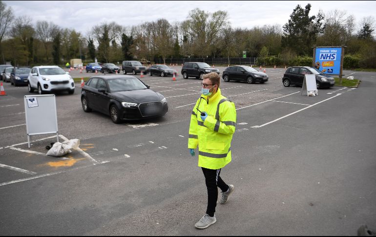 Conductores hacen fila para que les tomen una muestra desde su auto, en un lugar donde se realizan pruebas de coronavirus en Chessington, Inglaterra. EFE/A. Rain