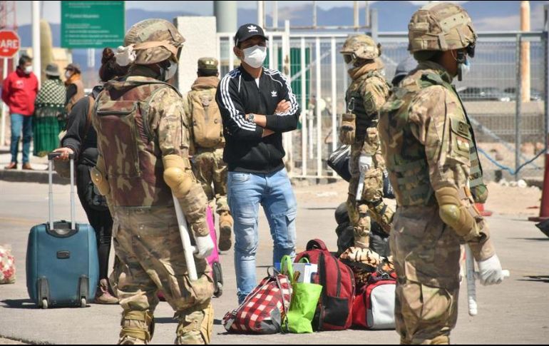 Un ciudadano boliviano proveniente de Chile aguarda este sábado al control sanitario para entrar a su país y pasar una cuarentena de 14 días en un campamento de la localidad de Pisiga. EFE/E. Huascar