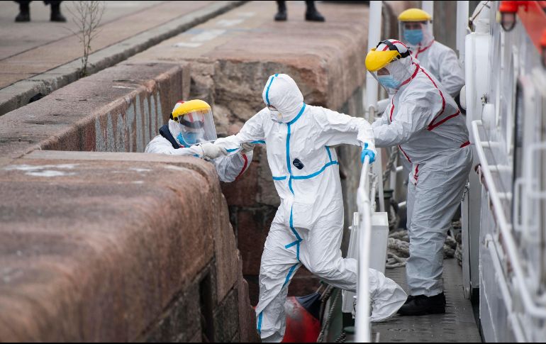 Un pasajero con COVID-19 sale hoy de un crucero australiano en Montevideo, Uruguay, para ser trasladado a un hospital. AP/M. Campodonico