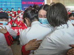 AEROPUERTO. Personal sanitario del Primer Hospital Bethune de la Universidad de Jilin se despide de sus colegas de Wuhan luego de que se levantó el bloqueo. EFE