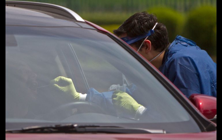Un trabajador toma hoy una muestra para prueba de COVID-19, en un sistema tipo 