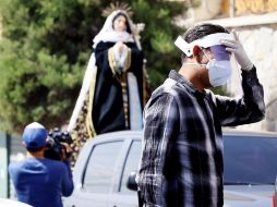 Fieles salen a la calle mientras pasan carros con una procesión con motivo de la Semana Santa en una parroquia de Tegucigalpa. EFE/H. Espinoza