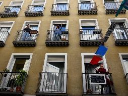 Habitantes bailan hoy desde sus balcones en Madrid, en el marco del estado de alarma por el que deben permanecer en las viviendas al menos hasta el 26 de abril. AFP/G. Bouys