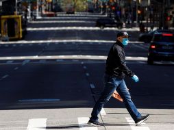 Un hombre protegido con cubrebocas cruza la Sexta Avenida este martes. EFE/J. Lane