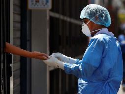 Trabajadores del ministerio de Salud toman muestras a domicilio para pruebas de coronavirus en Lima. EFE/ P. Aguilar